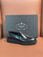 Prada unisex loafers, front view in dark metallic leather with strap and treaded sole