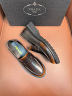 Dark leather loafer with apron strap, stitched moc toe, chunky treaded sole