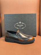Dark metallic leather loafer with apron strap and stitched moc toe, shown with box