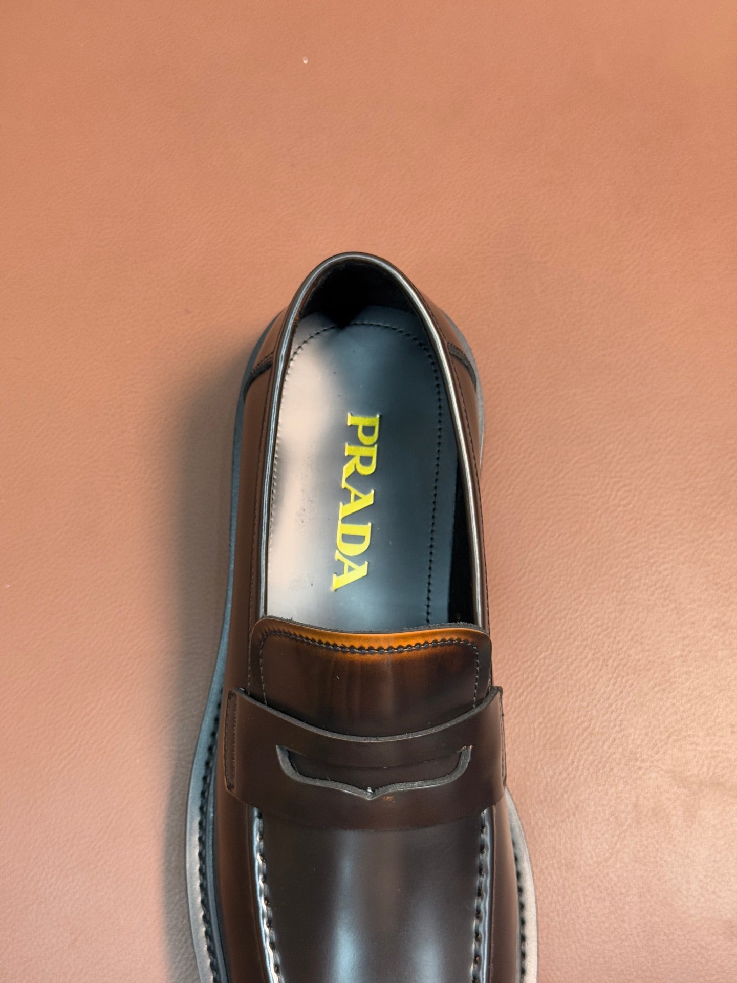 Dark metallic loafer with apron strap and stitched edge, Prada logo on insole