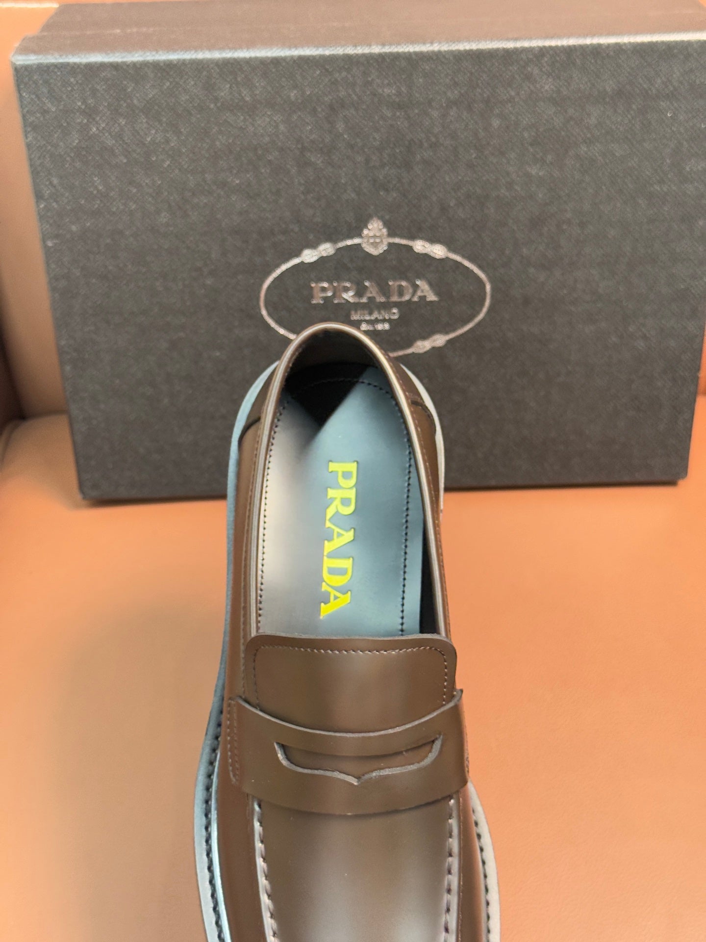Metallic brown loafer with penny strap and Prada logo on insole lining