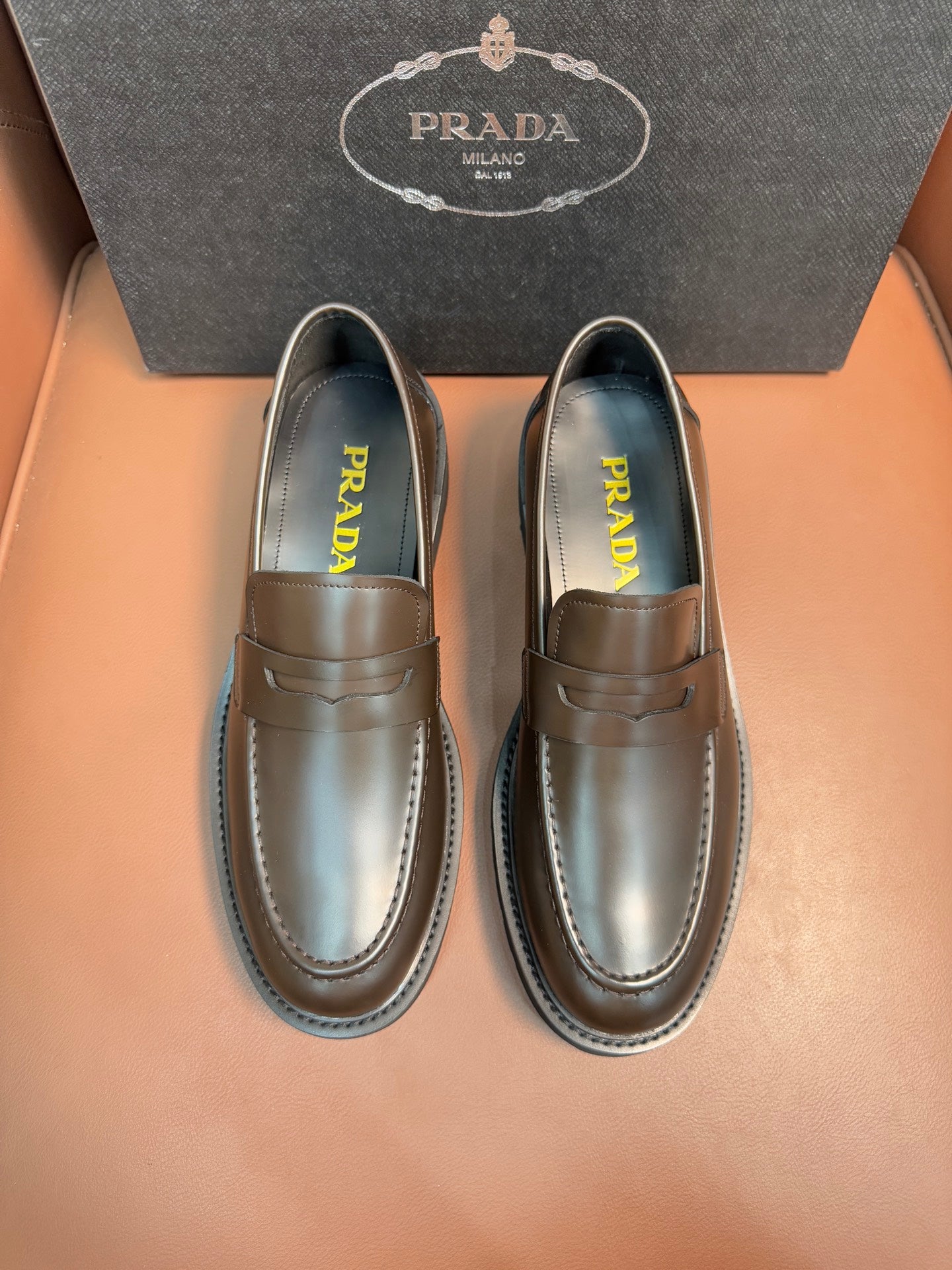 Metallic brown loafers with penny strap, stitched apron, Prada insole branding