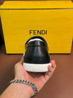 Fendi loafer back view with embossed logo on white sole, held in hand