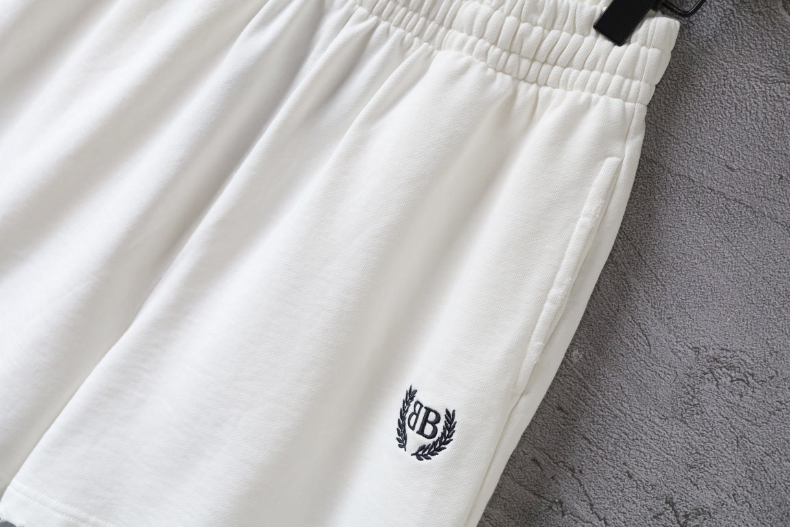 Balenciaga white shorts close-up with crest logo on leg