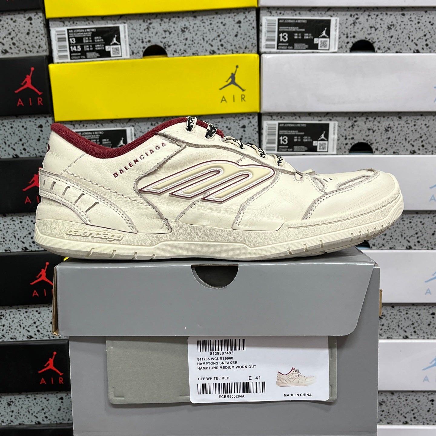 White Balenciaga low-top sneaker on box, maroon interior lining, lace-up design