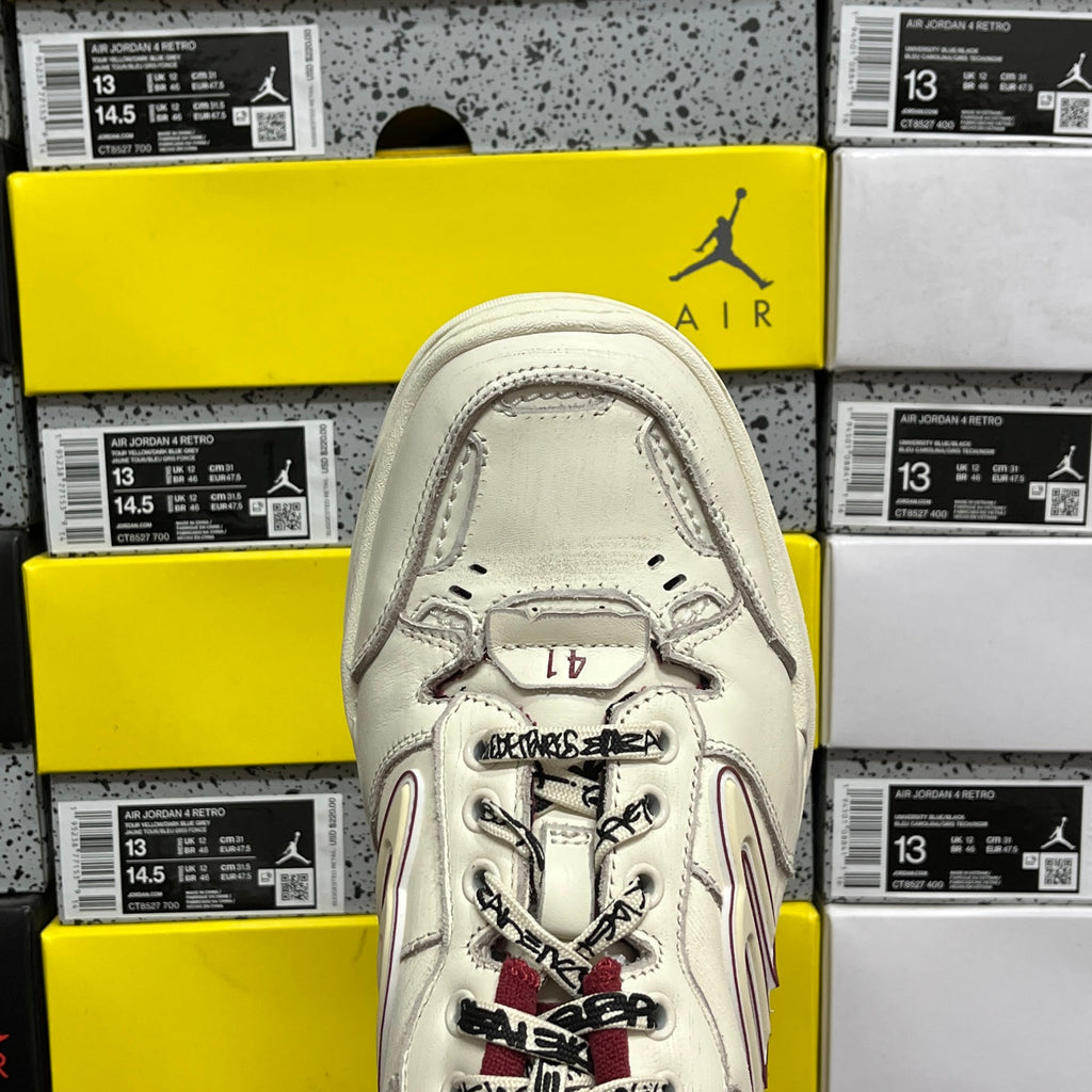 White Balenciaga sneaker tongue and laces, maroon accents, close-up top view