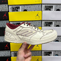White Balenciaga low-top sneaker with maroon collar, lace-up front, and thick sole
