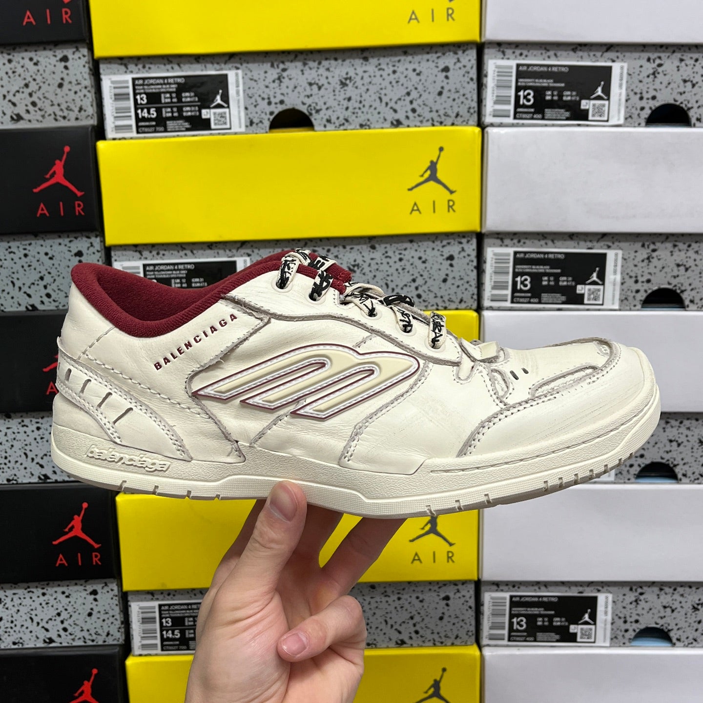 White Balenciaga low-top sneaker with maroon collar, lace-up front, and thick sole