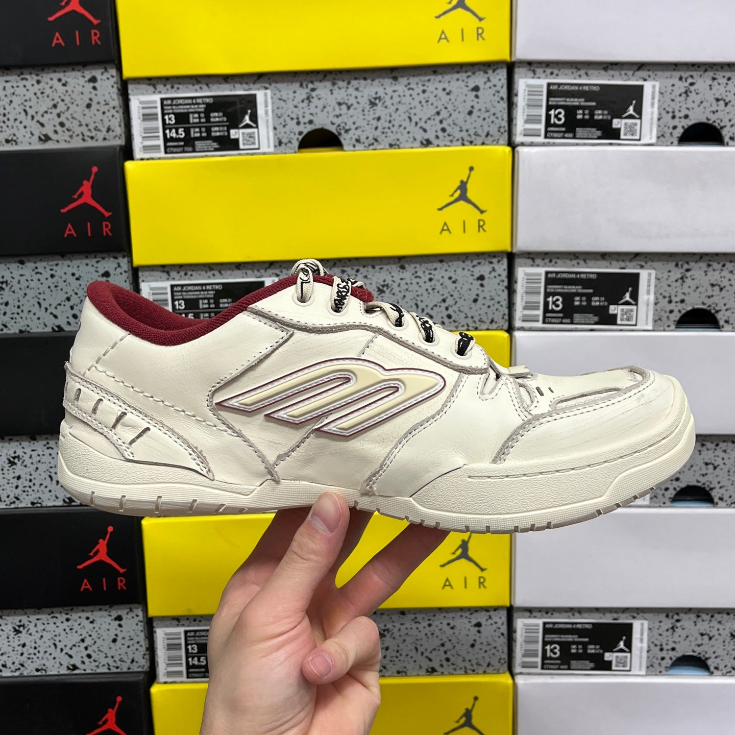 White Balenciaga low-top sneaker, maroon collar and interior, front side view
