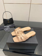 Beige braided-strap slide sandals with open toe, shown on black display box