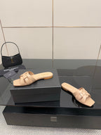 Beige braided-strap slide sandals on black display box, open toe, flat sole