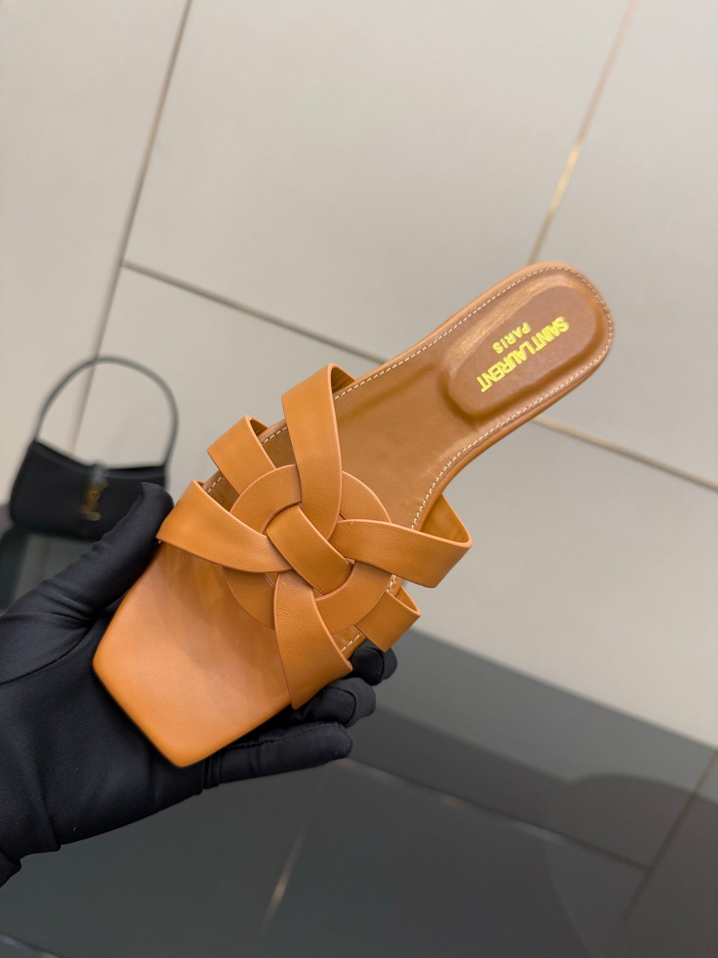 YSL women's orange woven slide sandal close-up, crossover straps and cushioned insole