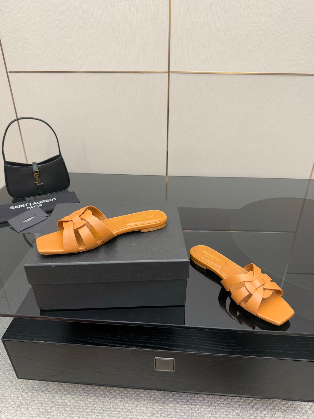 YSL women's orange woven slide sandals, side view of flat slip-on design
