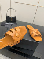 YSL women's orange woven slide sandals close-up, braided crossover strap upper