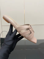 Women's light beige braided slide sandal held in hand, open toe