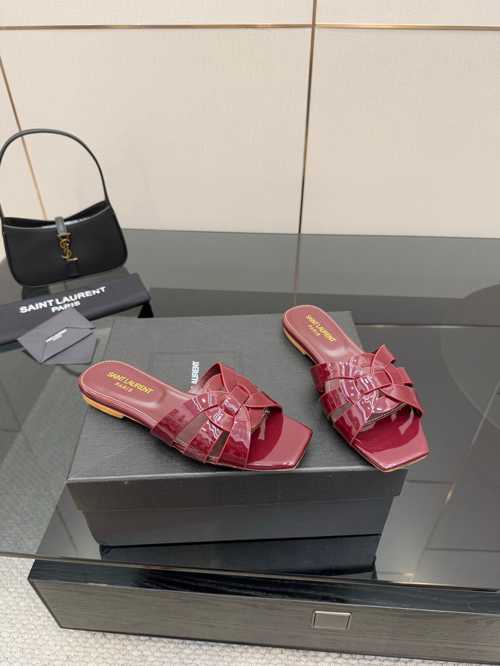 YSL pink bow mules on display, glossy open-toe slip-on sandals with pink strap bows
