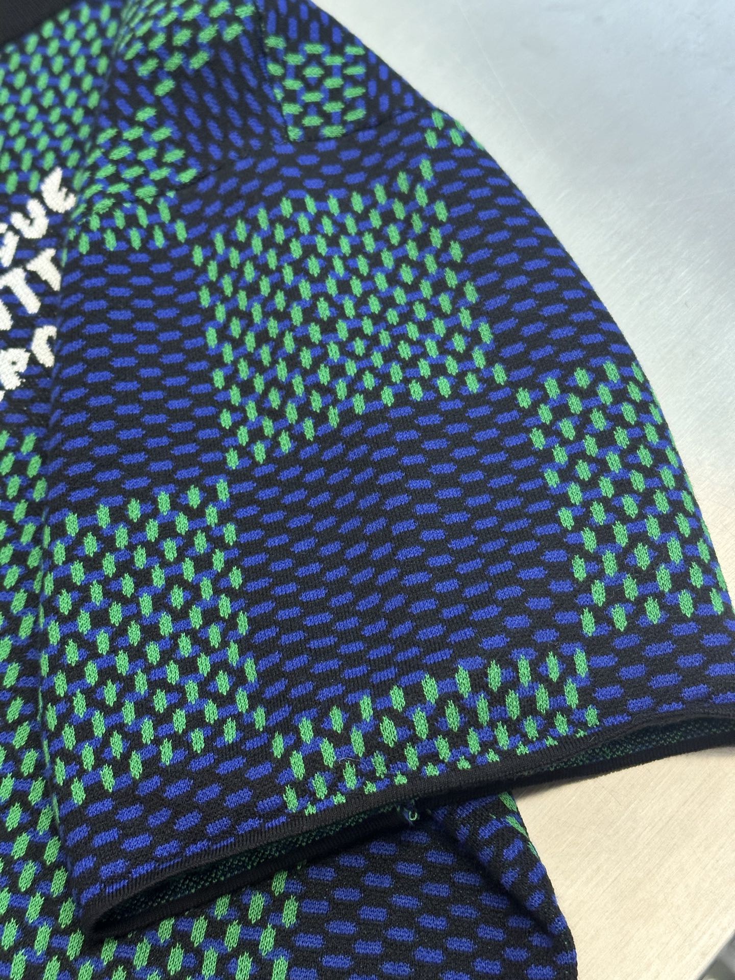 Louis Vuitton side and hem view of blue and green check T-shirt with ribbed trim at bottom.
