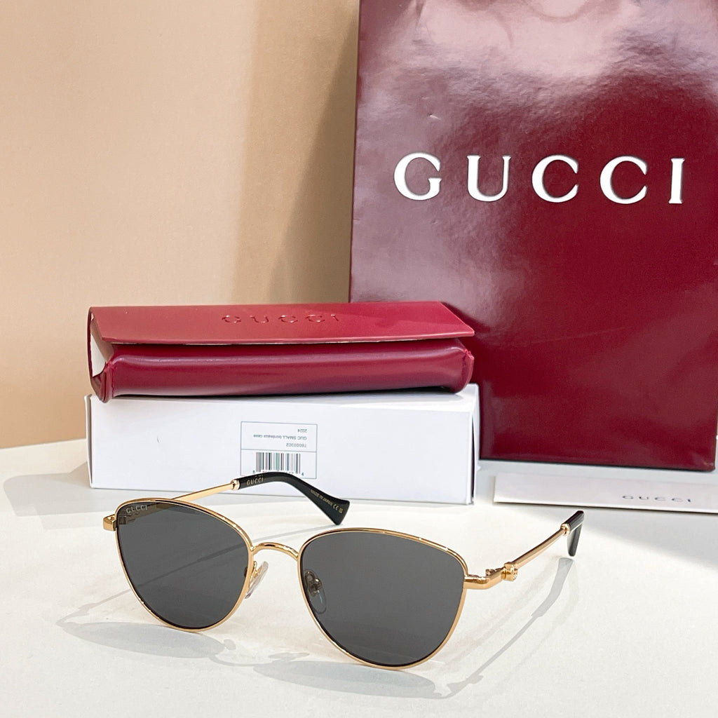 Sunglasses with gold frame and dark gray tinted lenses.