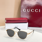 Sunglasses with gold frame and dark gray tinted lenses.