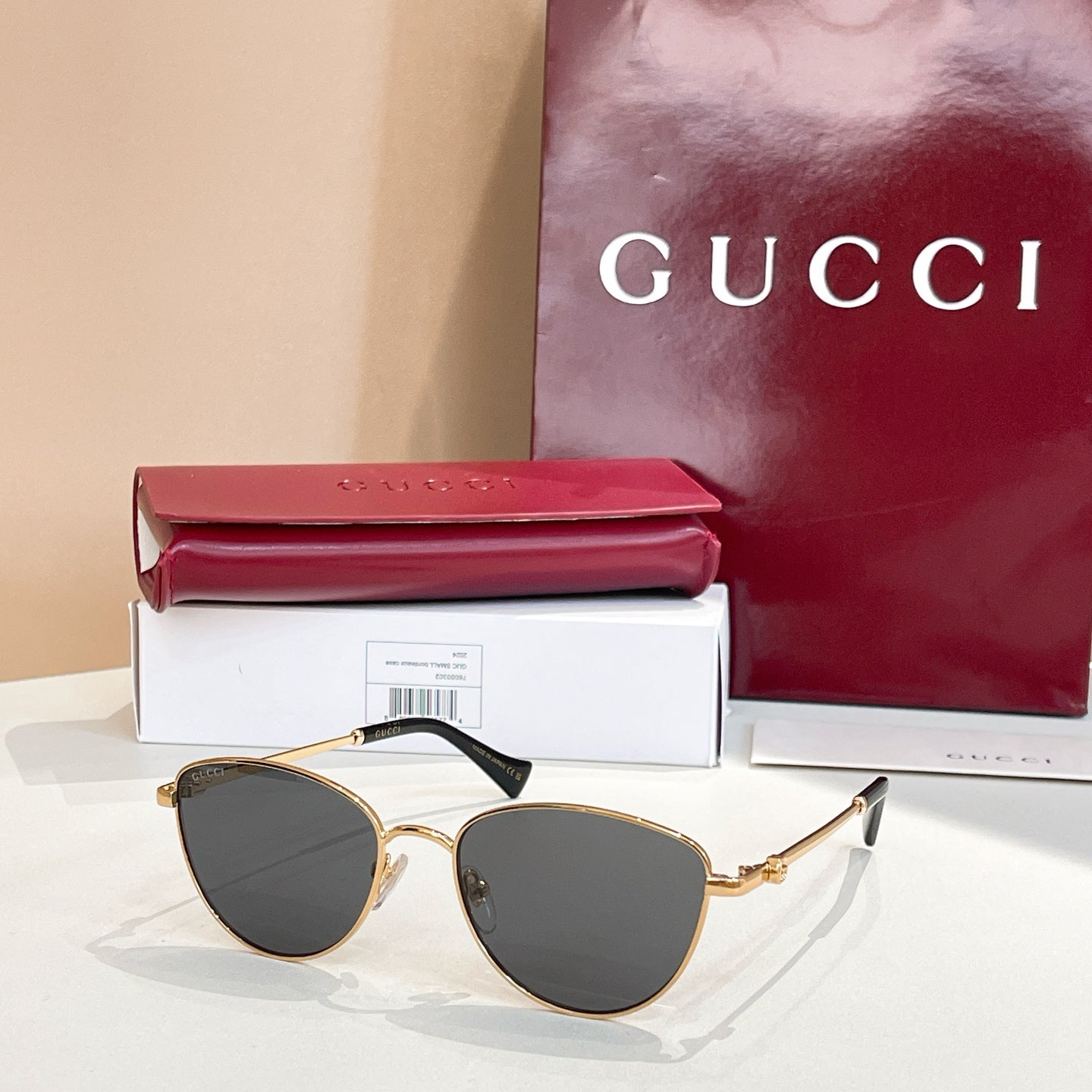 Sunglasses with gold frame and dark gray tinted lenses.