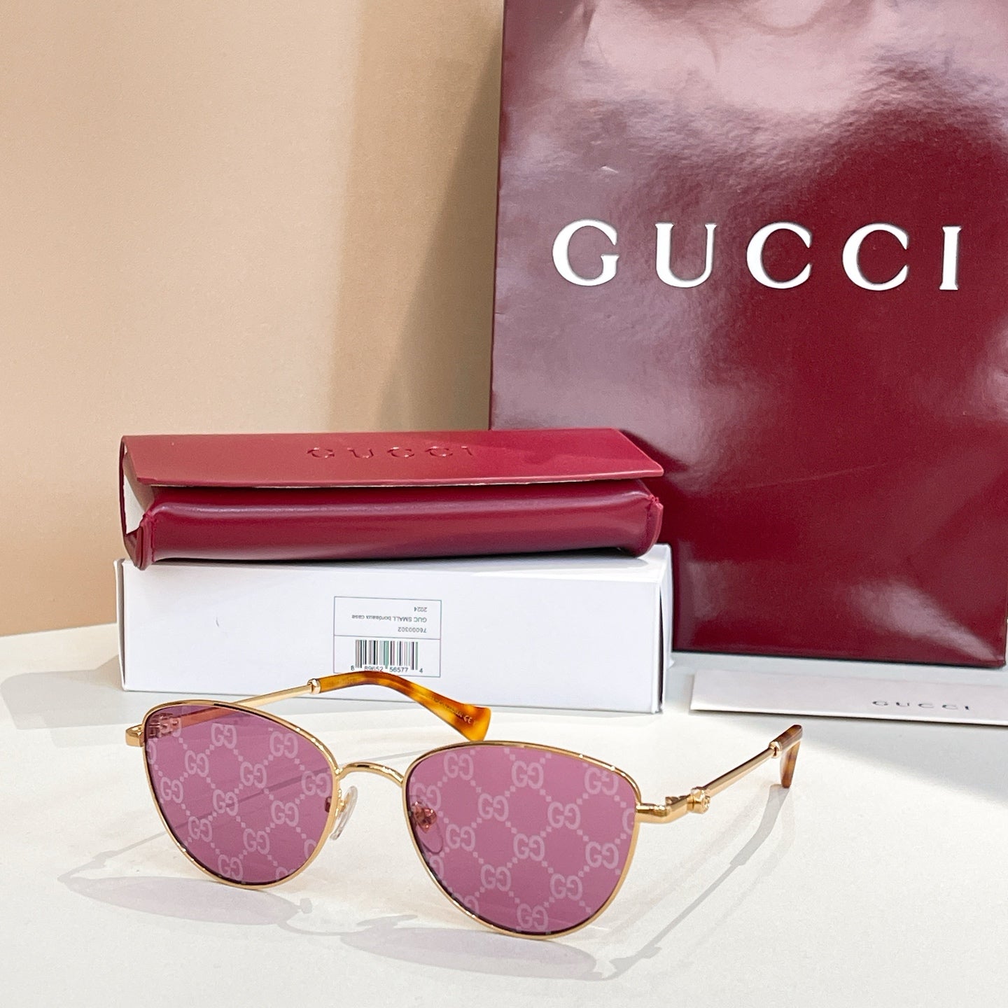 Sunglasses with gold frame, purple lenses, and GG logo temples.