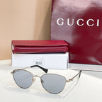 Gucci sunglasses with gold frame and light-blue tinted lenses.