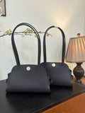 Hermes bag with top handles, dark body, front flap and small side hardware details.