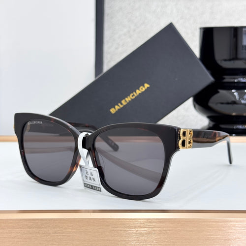Balenciaga sunglasses with dark lenses, black frames, and gold B logo detail