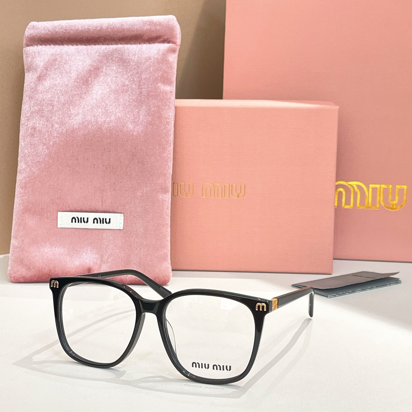 MiuMiu eyeglasses with black frame and clear lenses, with pink storage pouch
