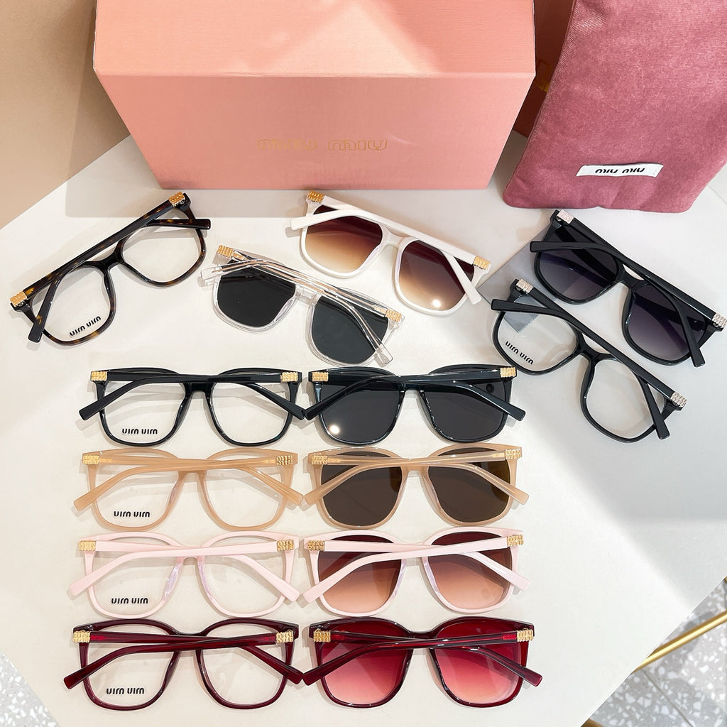 Assorted eyeglasses and sunglasses on tray with pink box and pouch