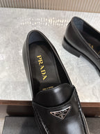 Black leather loafer showing Prada logo on insole and stitched front