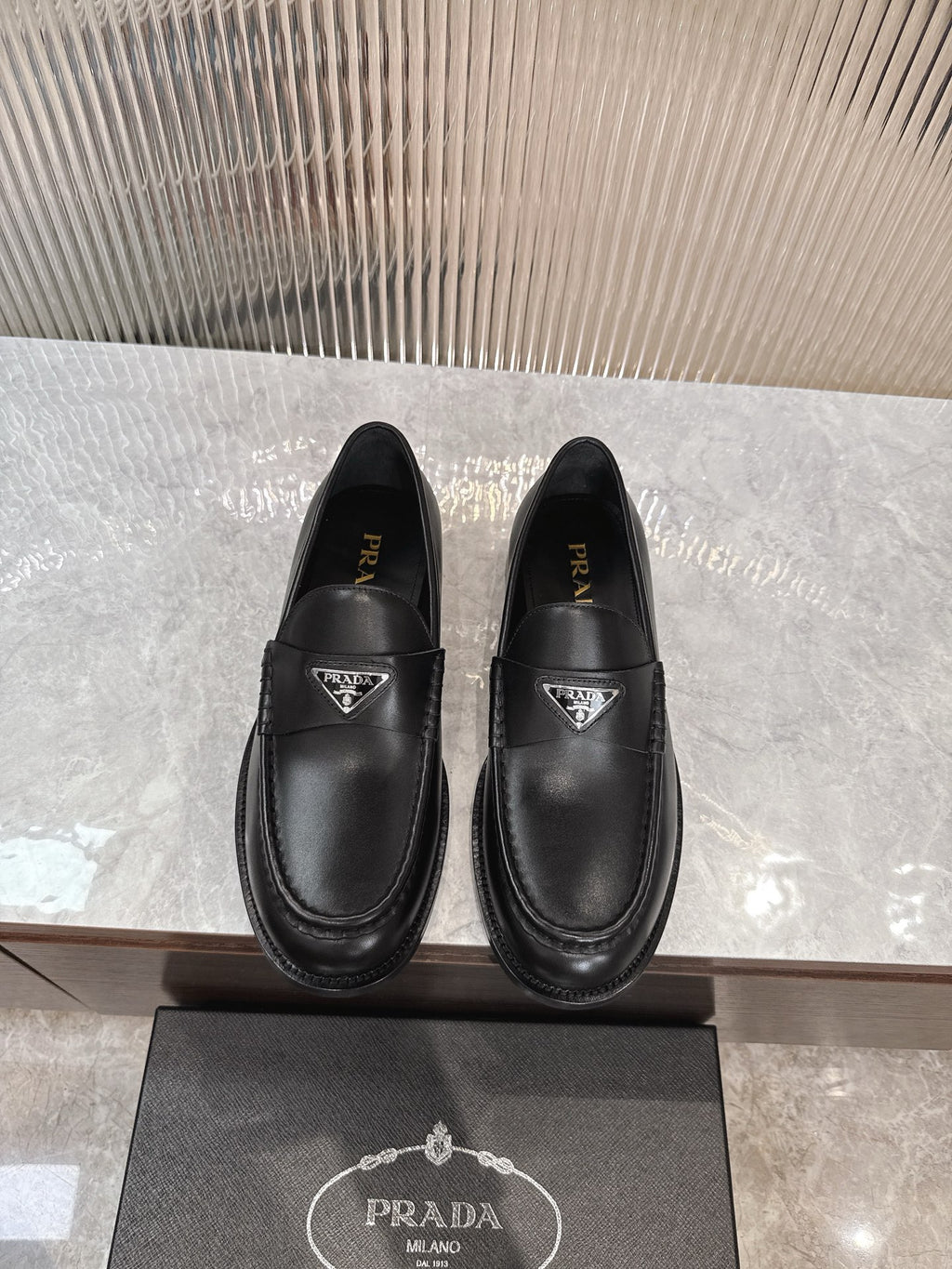 Unisex black leather loafers with Prada triangular logo on front