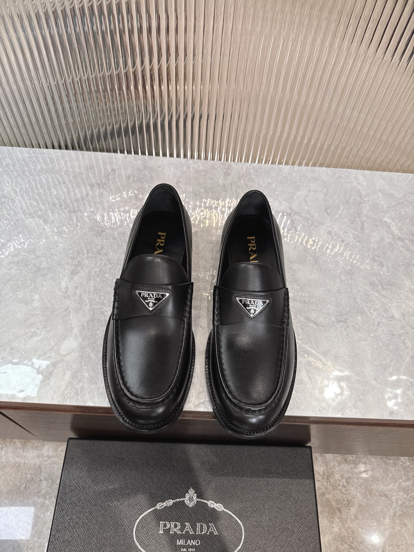 Prada unisex black leather loafers with triangular logo at the vamp