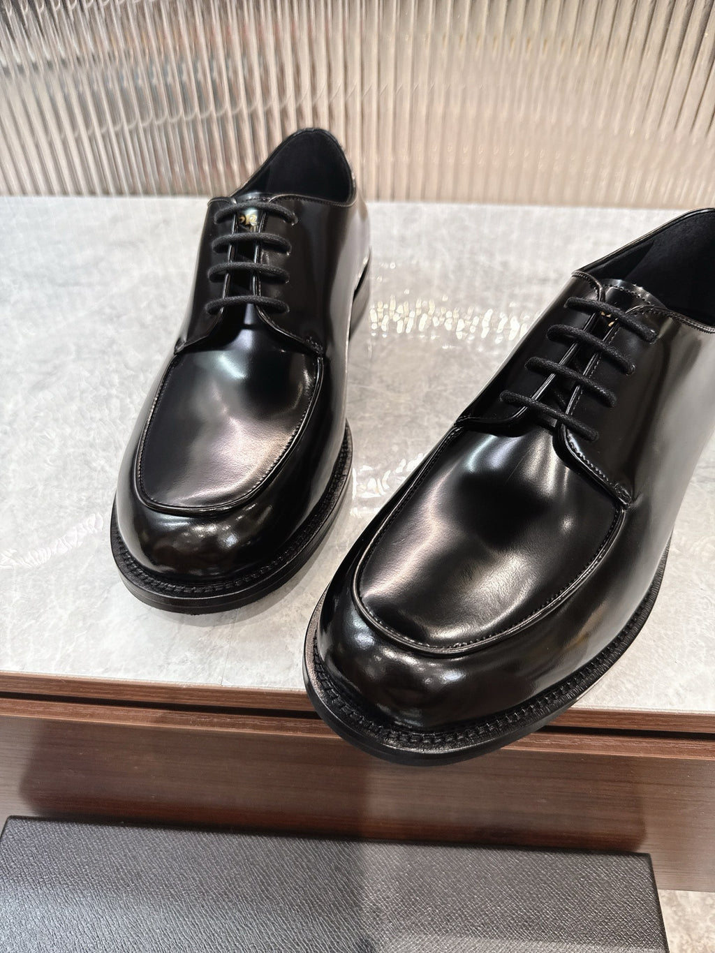 Prada unisex lace-up dress shoes, glossy black leather, metal eyelet lacing.