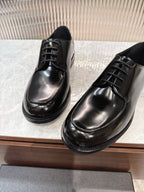 Prada unisex lace-up dress shoes, glossy black leather, metal eyelet lacing.