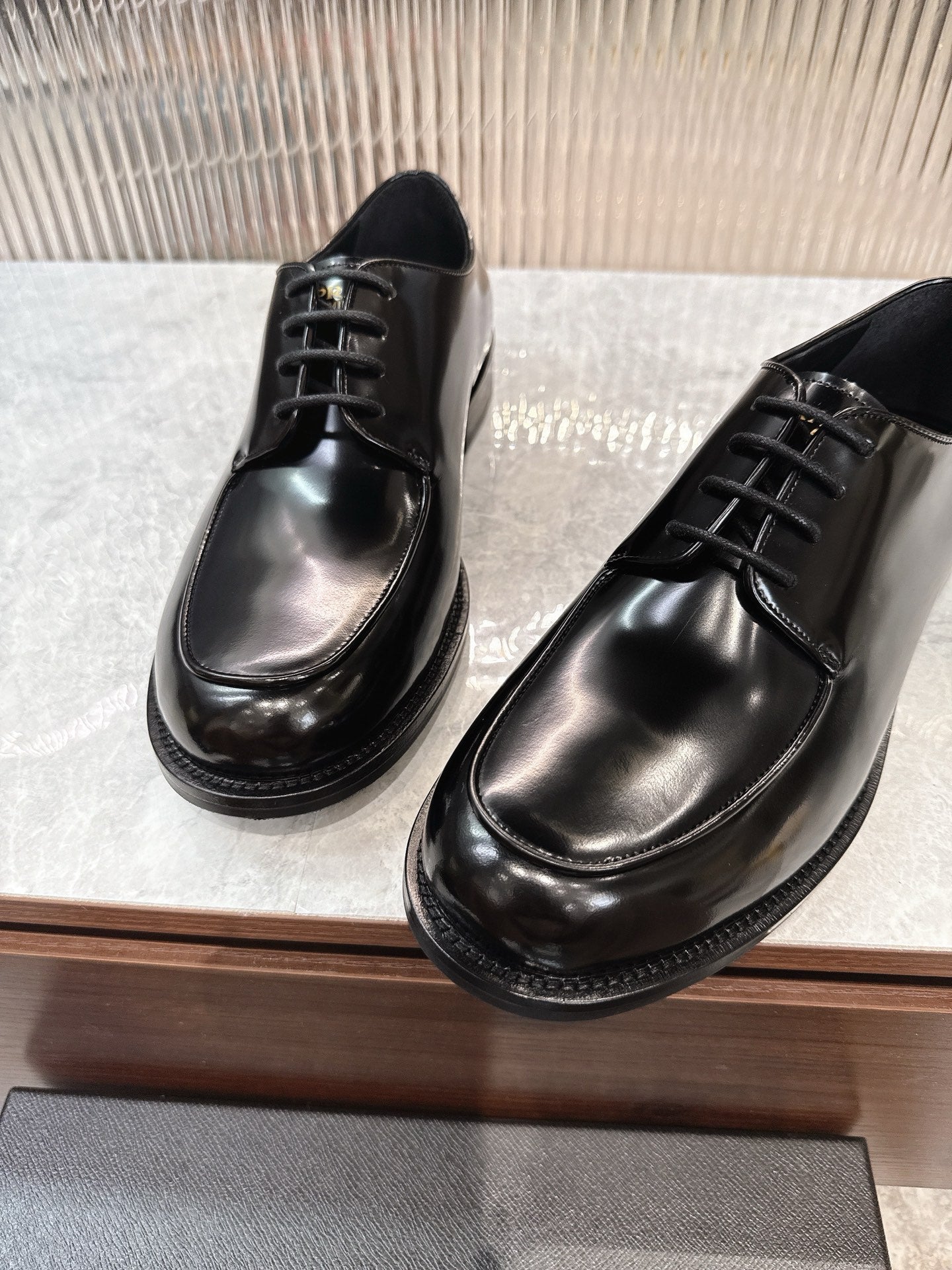 Prada unisex lace-up dress shoes, glossy black leather, metal eyelet lacing.