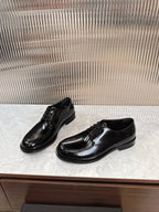Prada unisex lace-up dress shoes, glossy black leather, front and side angles.