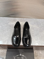 Prada unisex lace-up dress shoes, glossy black leather with rounded toe.