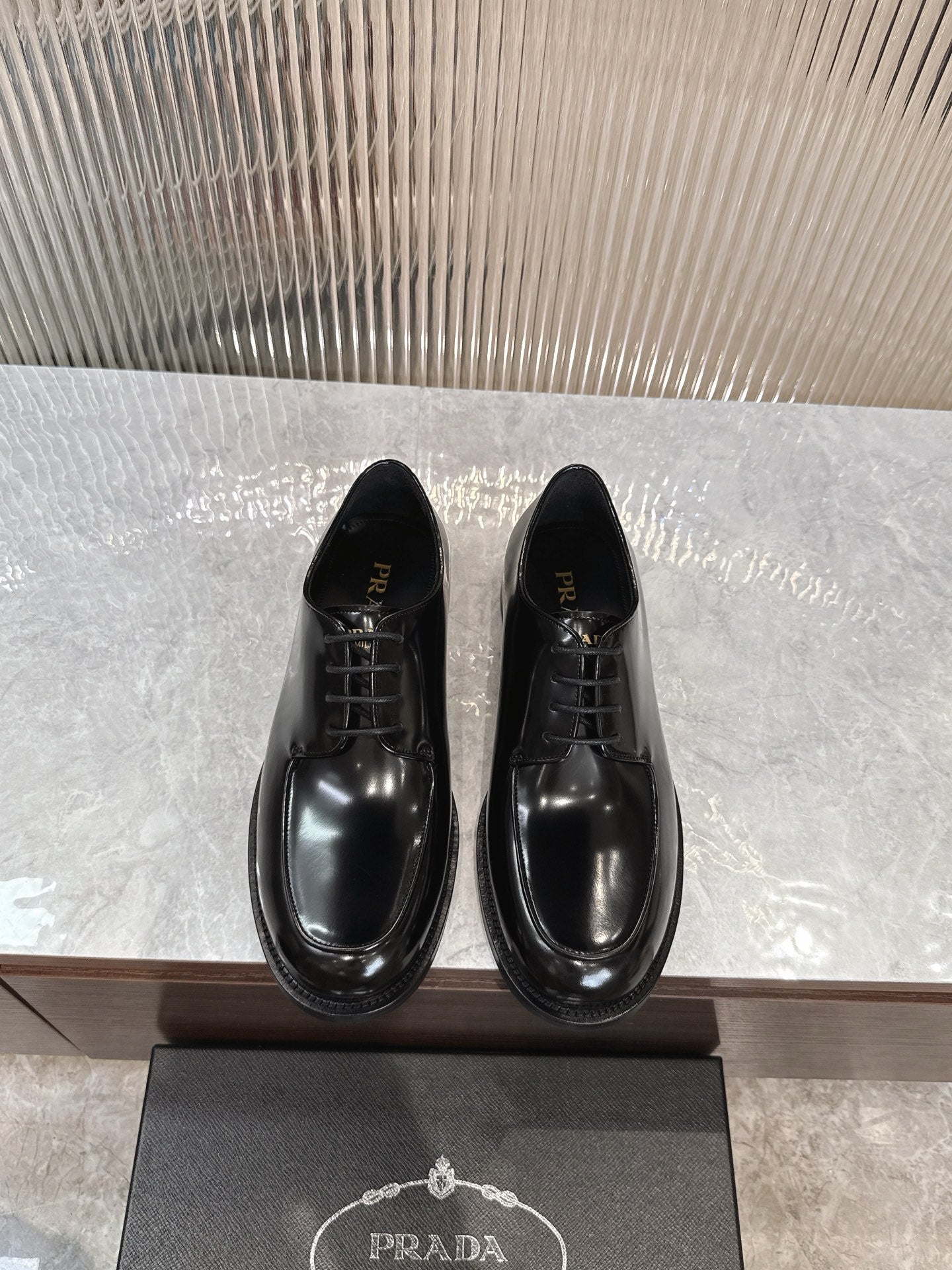 Prada unisex lace-up dress shoes, glossy black leather with rounded toe.