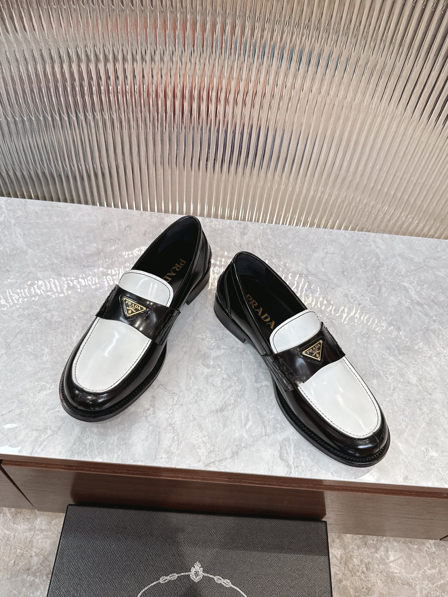 Prada unisex loafers, black leather slip-on with white strap and gold emblem