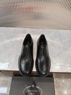 Black lace-up leather shoes with rounded toe and low profile sole
