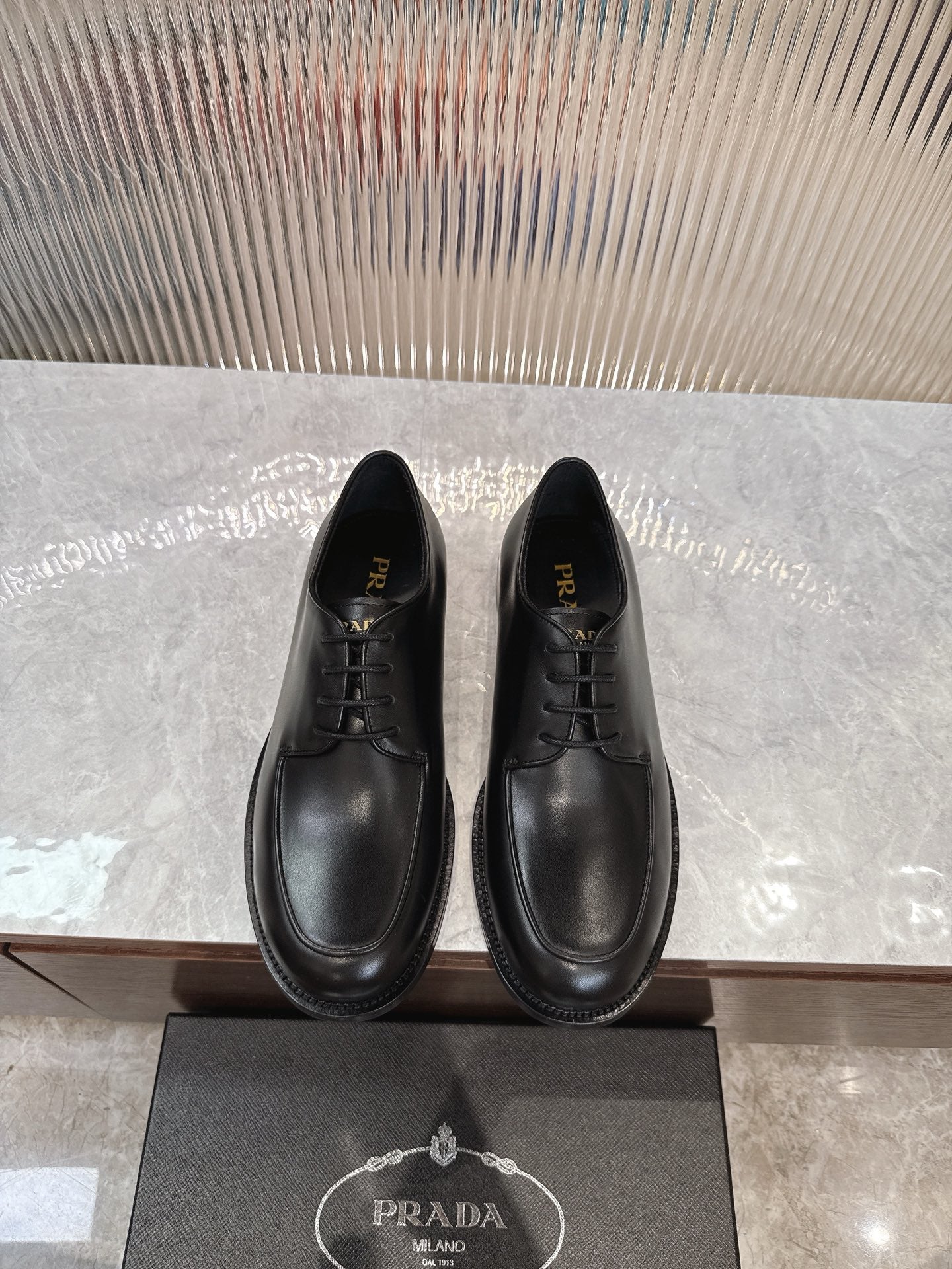 Black lace-up leather shoes with rounded toe and low profile sole