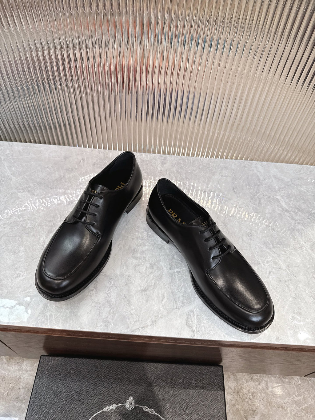 Black lace-up leather shoes, angled view, rounded toe and stitched upper