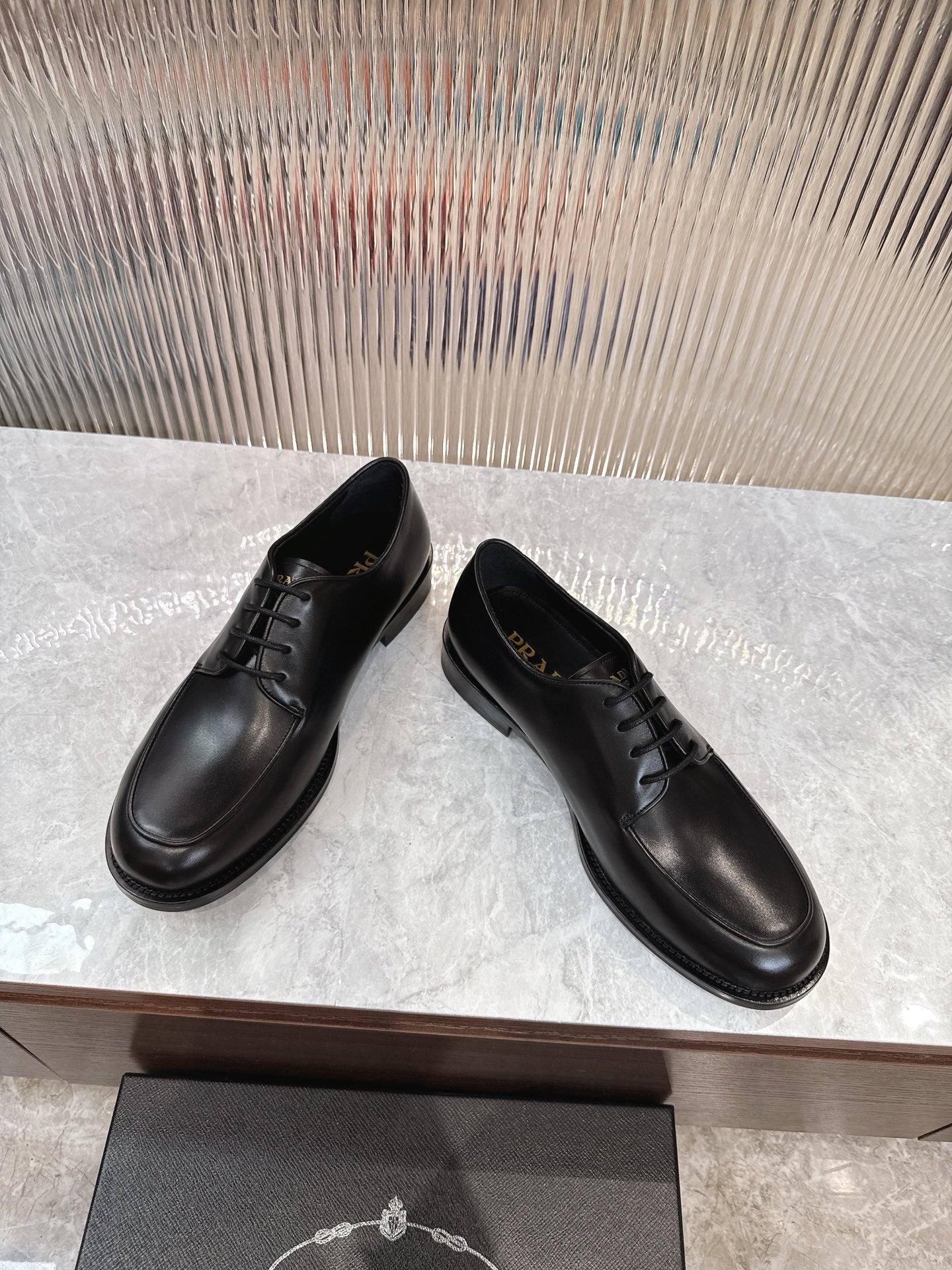 Black lace-up leather shoes, angled view, rounded toe and stitched upper