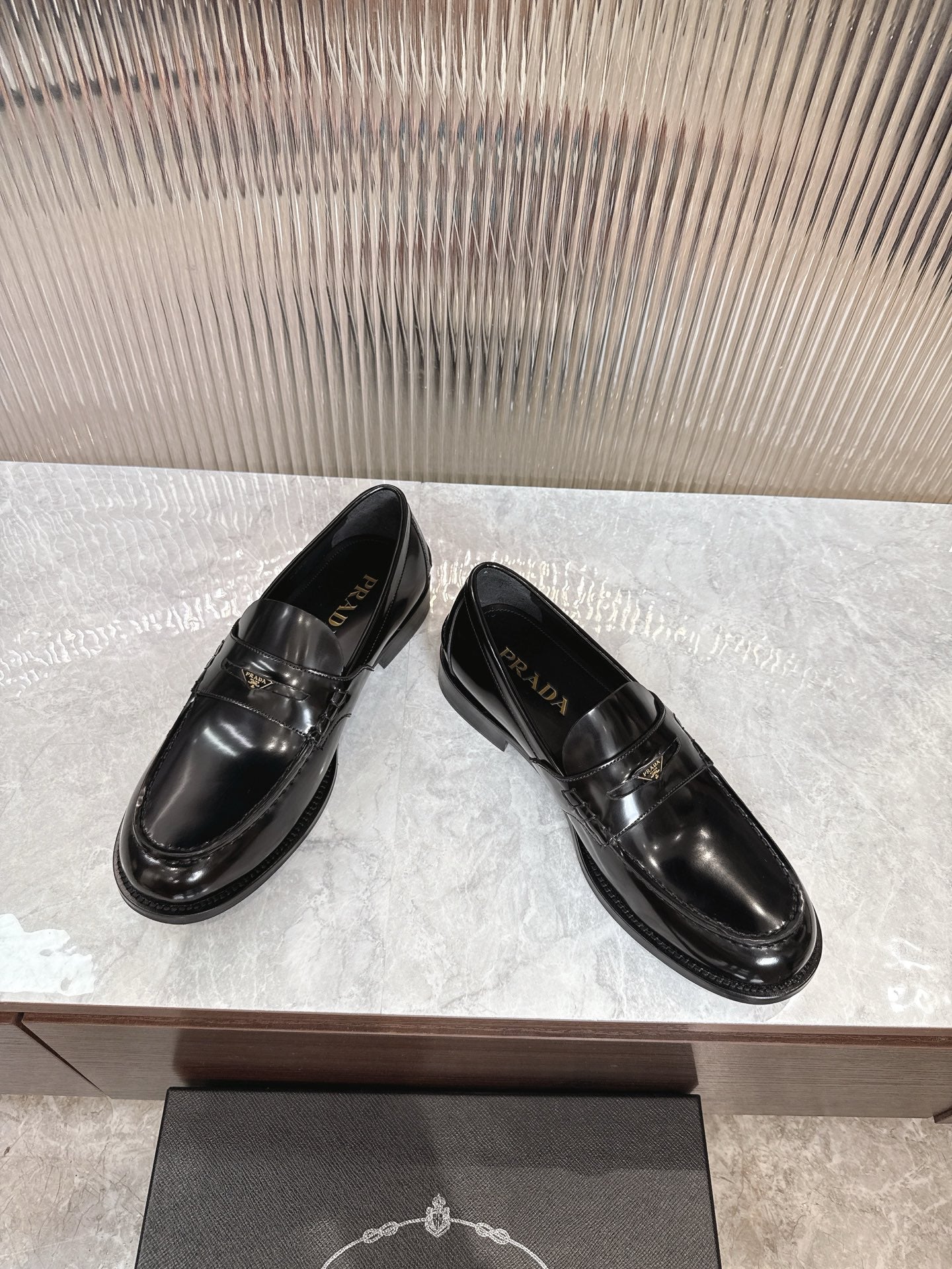 Prada unisex loafers, black leather, side angle pair with glossy finish