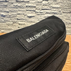Black crossbody bag with BALENCIAGA logo label on the front.
