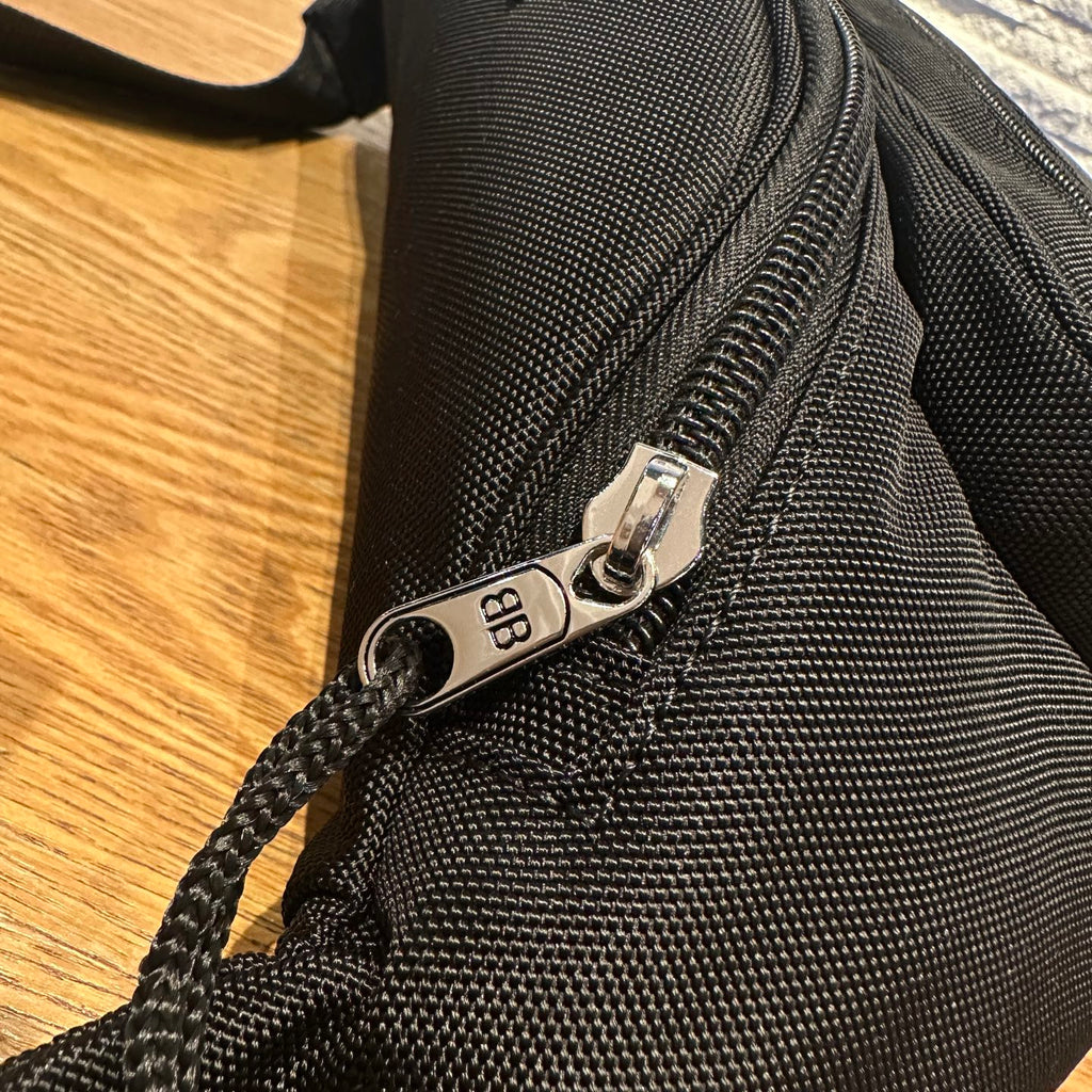 Balenciaga bag zipper pull and hardware on black textured fabric