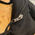 Balenciaga bag zipper pull and hardware on black textured fabric