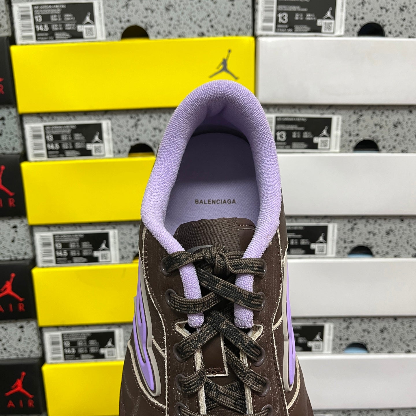 Brown leather sneaker tongue opening with Balenciaga label and purple lining.