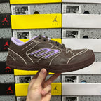 Brown leather sneakers with purple logo patch and black laces.